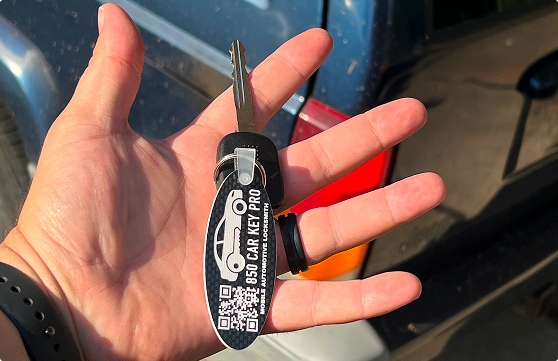 An open hand holding a set of keys with an 850 Car Key Pro keychain attached.