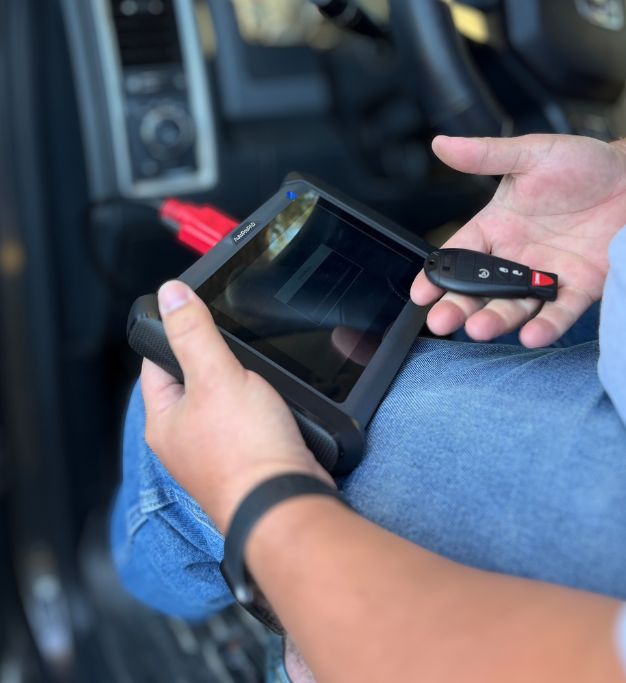 Person programming car key fob with diagnostic tool